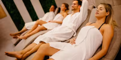 Two couples relaxing in lounging chairs in spa